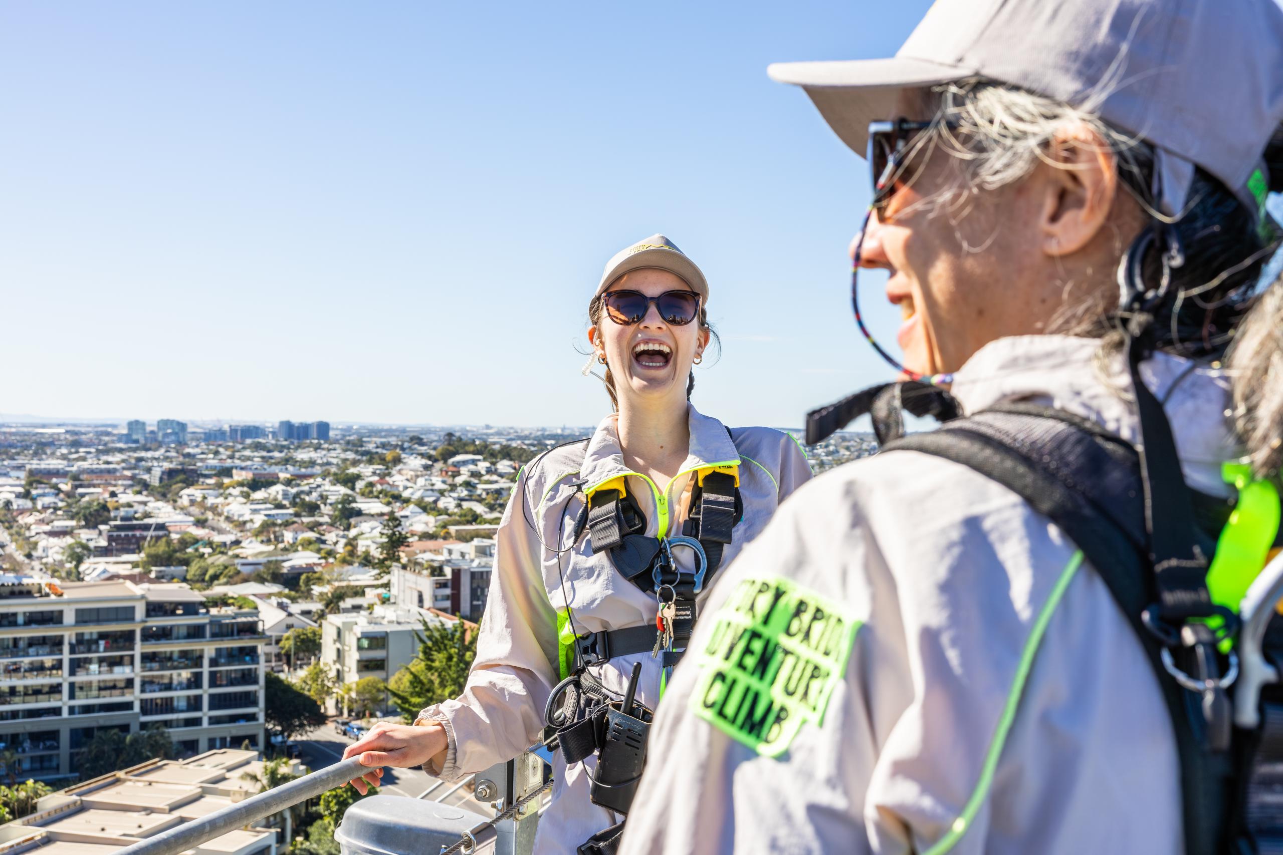 Climbers in safety harnesses on the Story Bridge Adventure Climb with Brisbane River and city views
